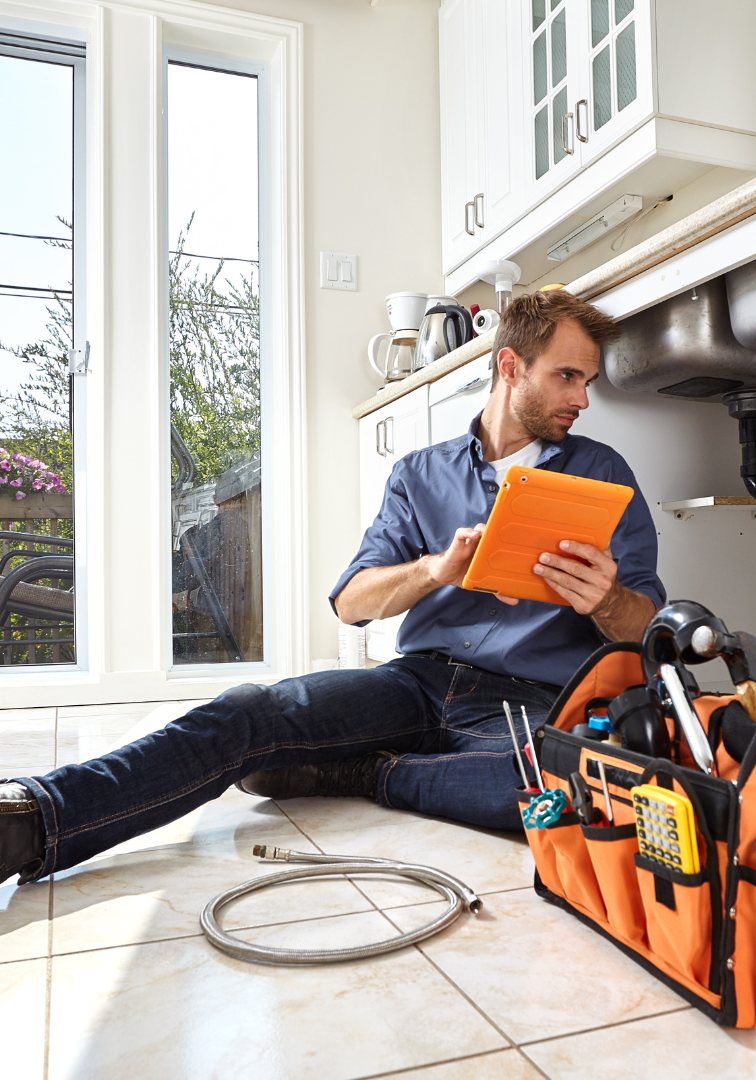 Plumber Under Sink With Orange Tool Bag